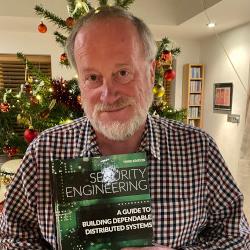 Portrait photo of Ross Anderson holding a text book
